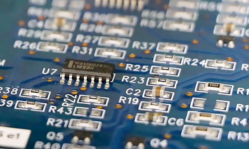 Close up of printed circuit board packed with small components.