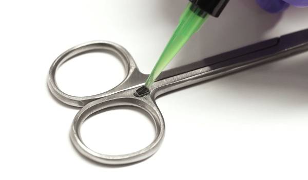 RFID Tag Being Secured to Surgical Scissors with Encapsulant