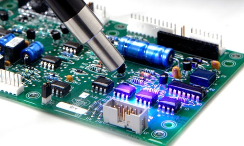 A printed circuit board coating is cured with a light-curing liquid filled lightguide.