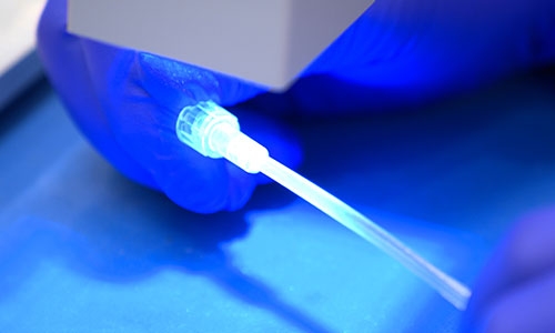 Curing a Dymax See-Cure-formulated adhesive that has been applied to a substrate.