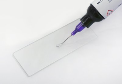 Dymax 3094-T-REV-A Low-Stress Clear Plastic Bonding Adhesive Being Applied To A Plastic Slide