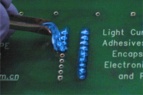 Dymax 9-20479-B-REV-A Blaues PCB-Schutz-Maskierungsmittel wird auf eine Leiterplatte aufgetragen